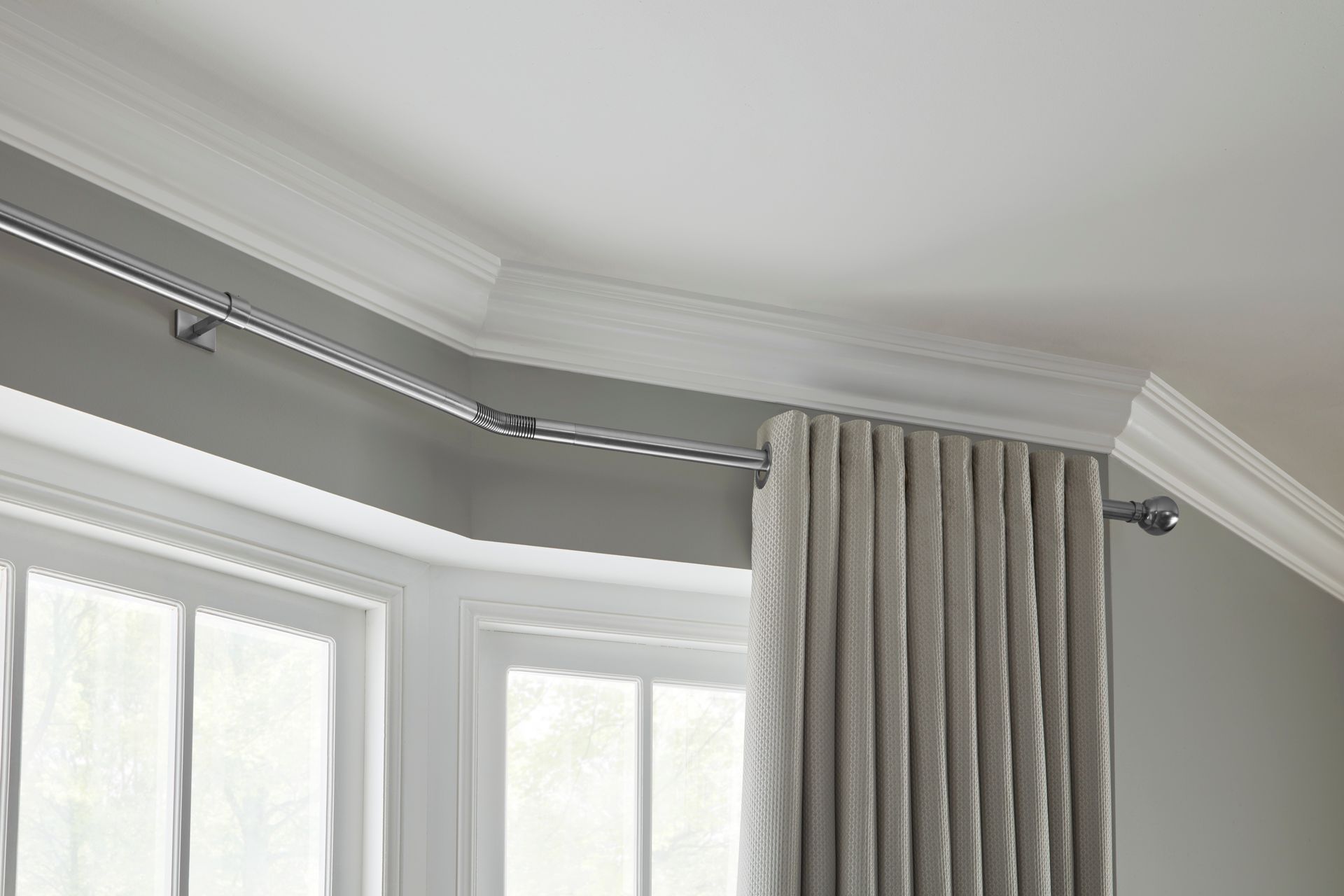 A window with a curtain hanging from the ceiling.