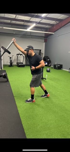 a man is holding a barbell in a gym .