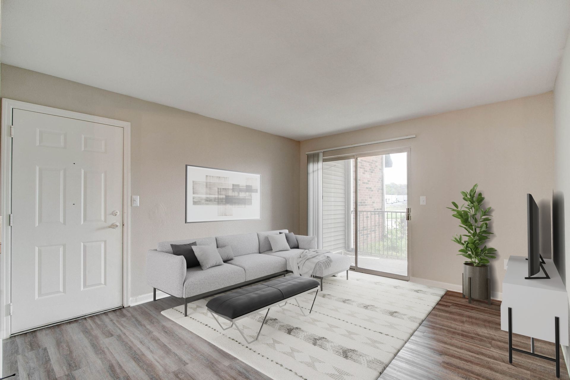 Living room with gray couch, bench, rug, and sliding door.