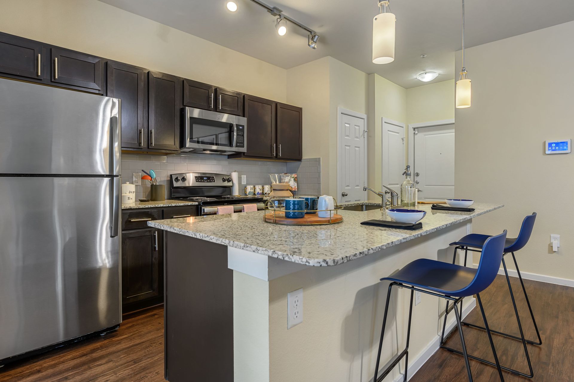 Apartment kitchen with stainless steel appliances and granite counter tops at Marquis SoCo in South Austin, TX.