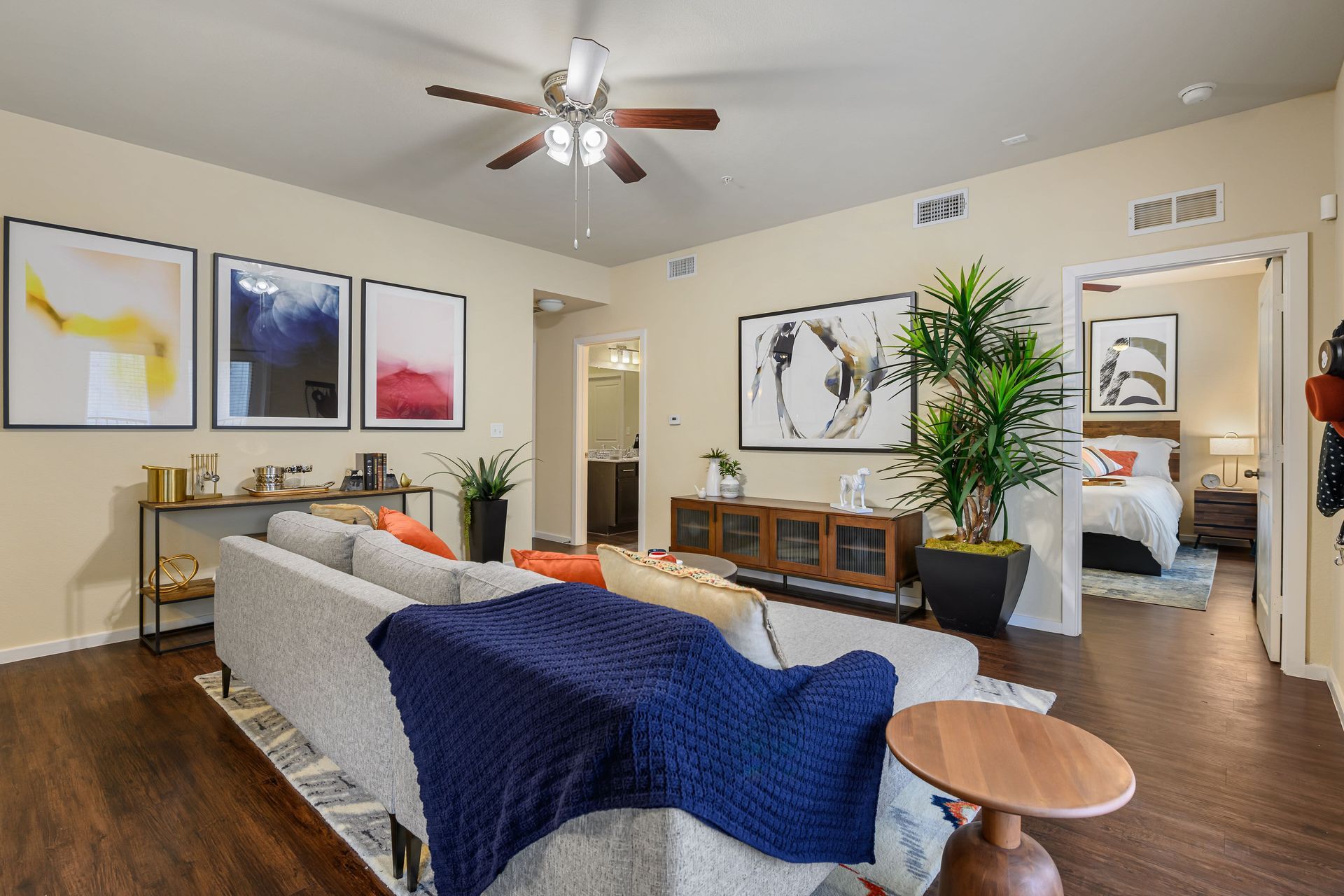 Apartment living room with a couch, table, and ceiling fan at Marquis SoCo in South Austin, TX.