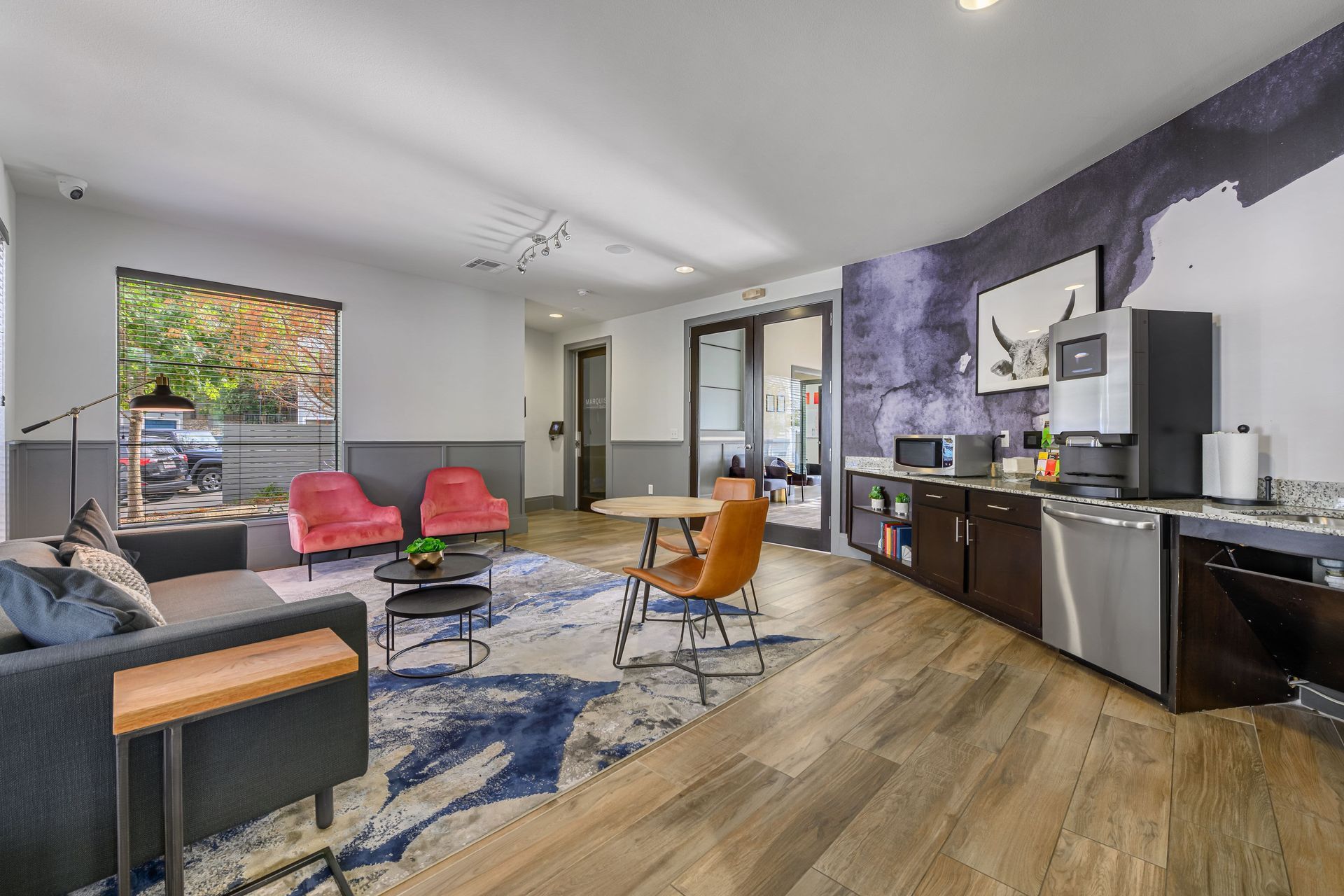 Clubhouse with a couch, chairs, a table, and a dishwasher at Marquis SoCo in South Austin, TX.