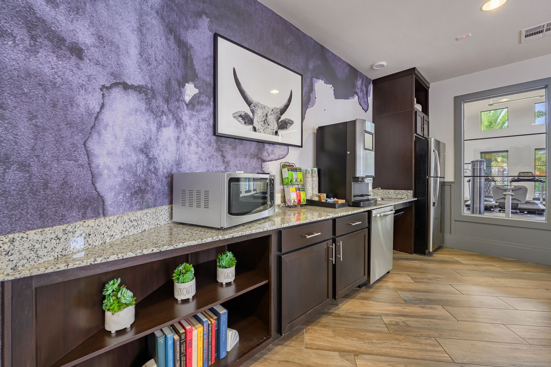 Apartment community kitchen with a purple wall, a microwave, and a refrigerator at Marquis SoCo in South Austin, TX.
