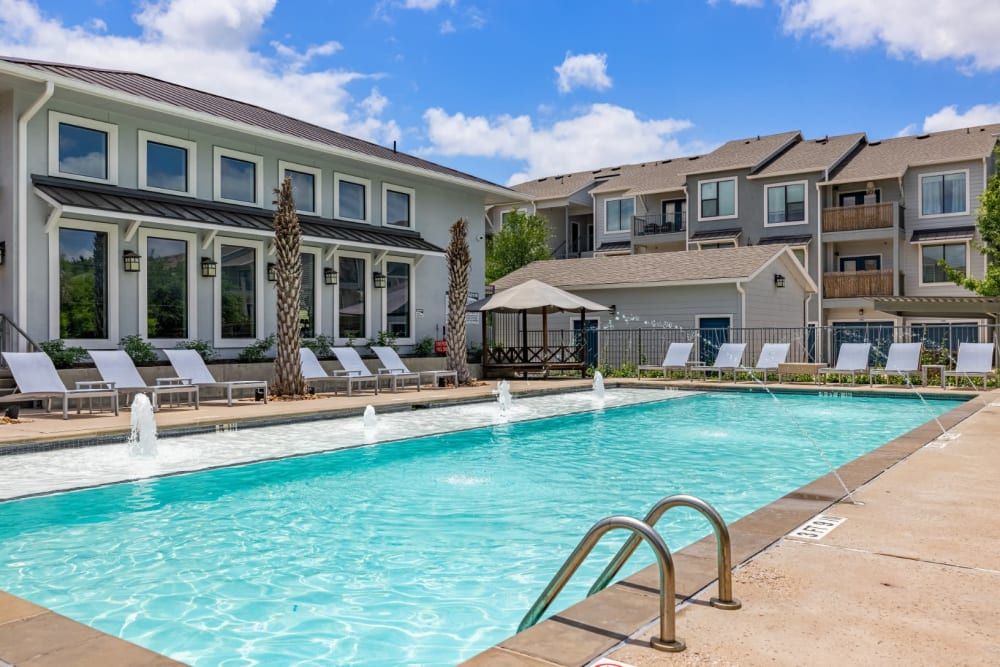 Apartment swimming pool in front of the apartment building at Marquis SoCo in South Austin, TX.