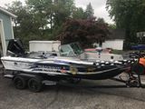 Small patriotic boat on a trailer with stars, stripes, and “We the People” lettering on a street.