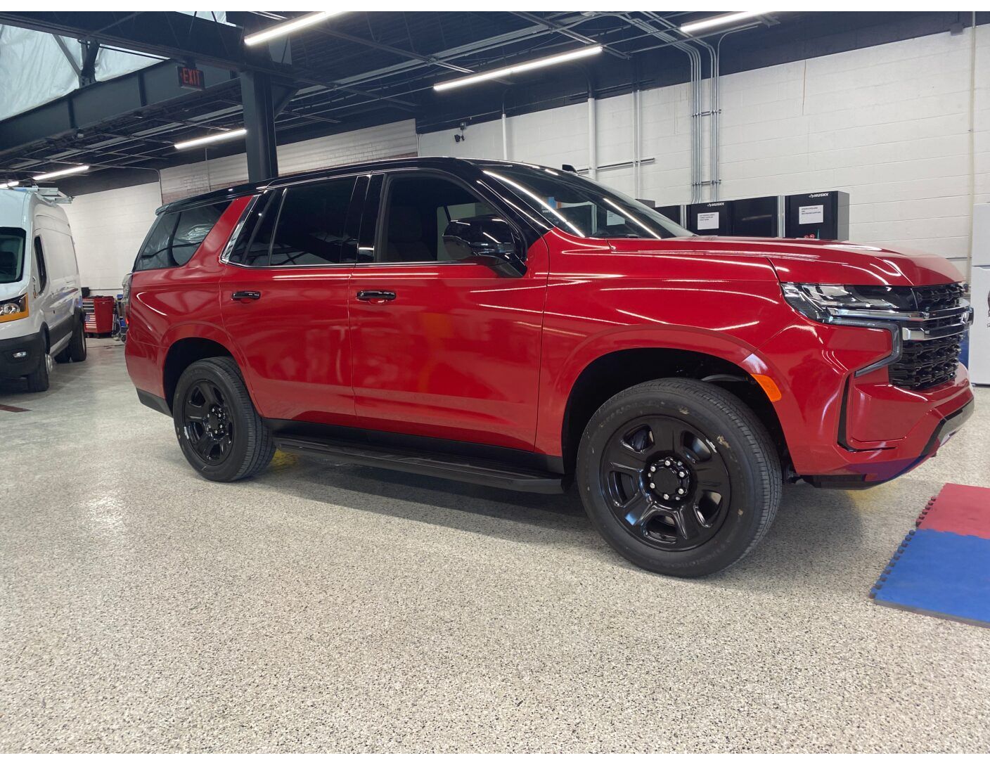 Red SUV parked indoors in a garage, shown in side view.
