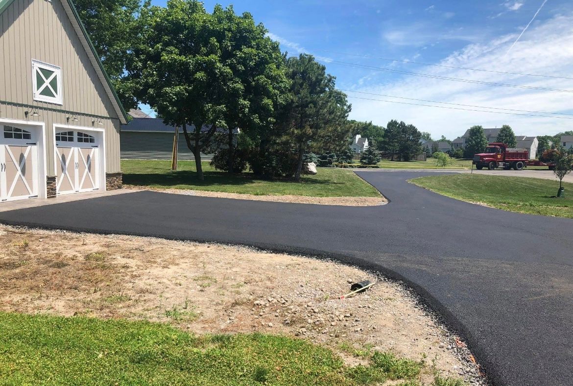 Professional installation of a new asphalt driveway by Universal Paving & Concrete in Rochester, NY, designed for long-term durability and ease of maintenance.