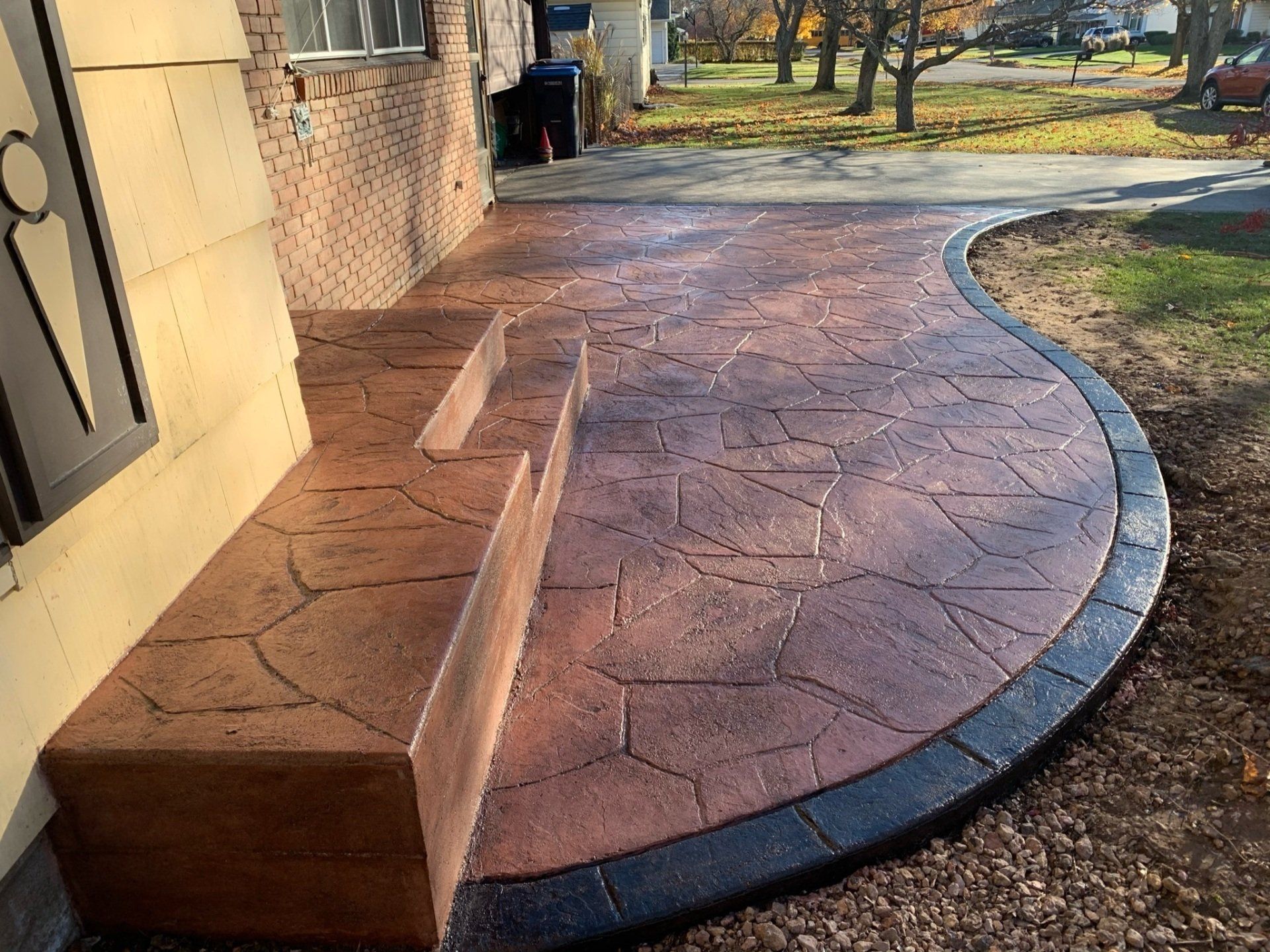 Universal Paving & Concrete transforming a backyard with a custom-stamped concrete patio in Rochester, NY, providing both beauty and durability.