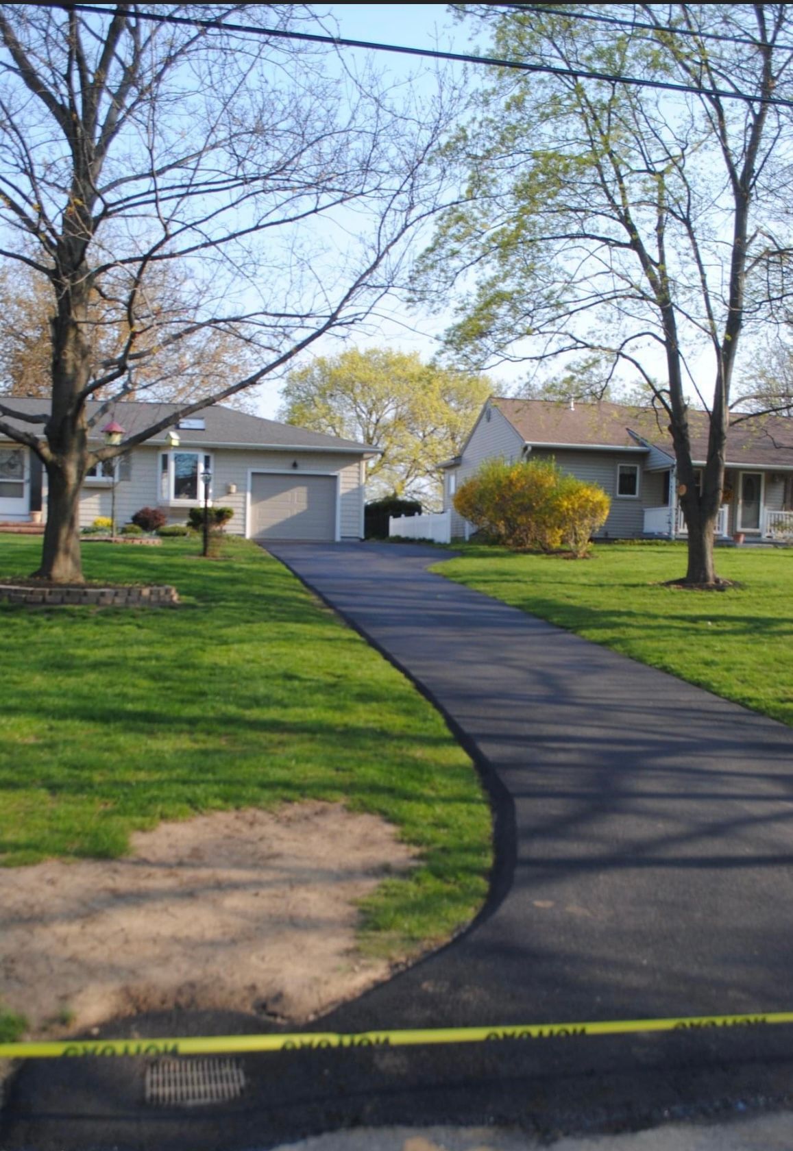 Universal Paving & Concrete team installing a new asphalt driveway in Rochester, NY, ensuring quality and long-lasting results.