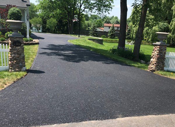 Freshly paved asphalt driveway in Rochester, NY, installed by Universal Paving & Concrete, providing a sleek and cost-effective solution for homeowners.