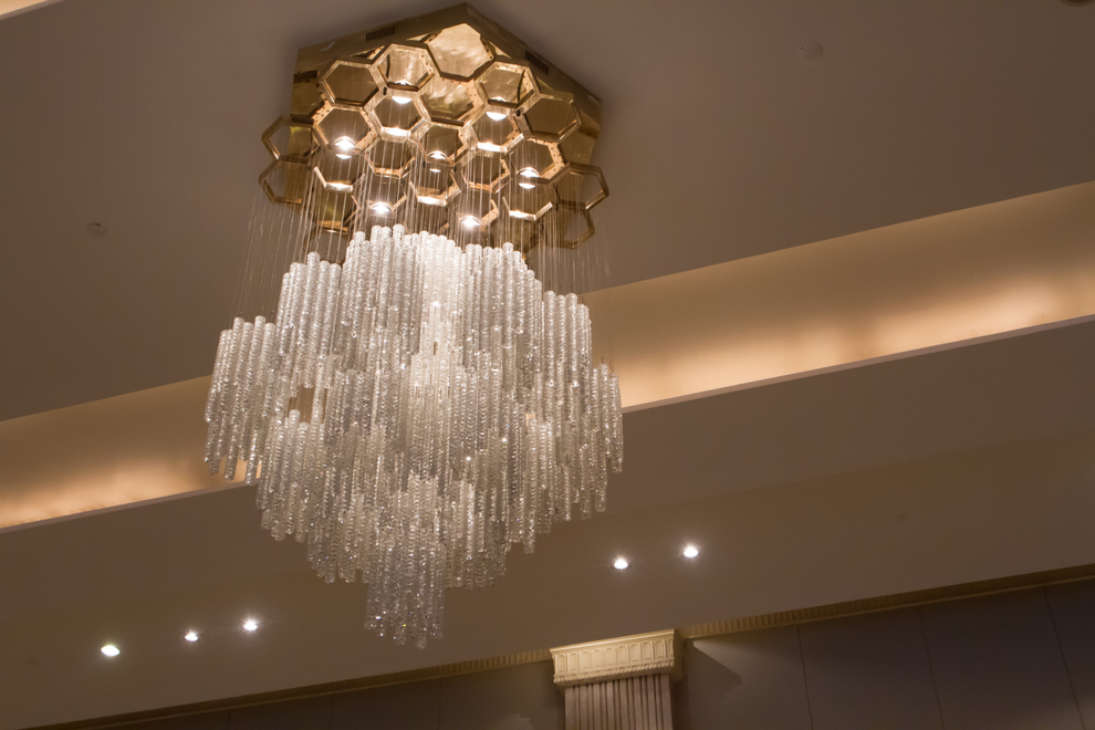 Large crystal chandelier hanging from a ceiling in a warmly lit interior room