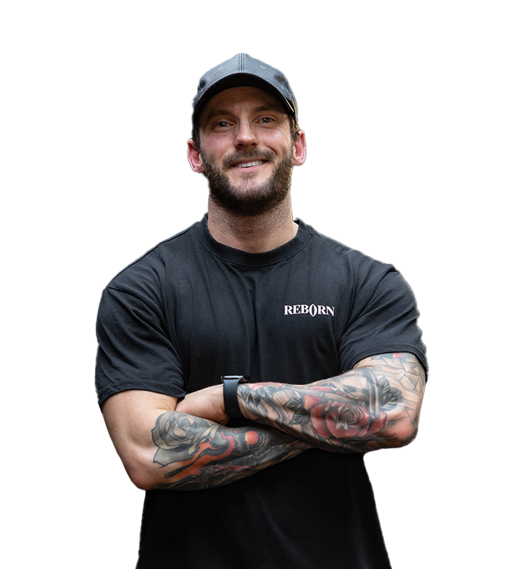 A man with a beard and tattoos is wearing a black shirt that says reborn