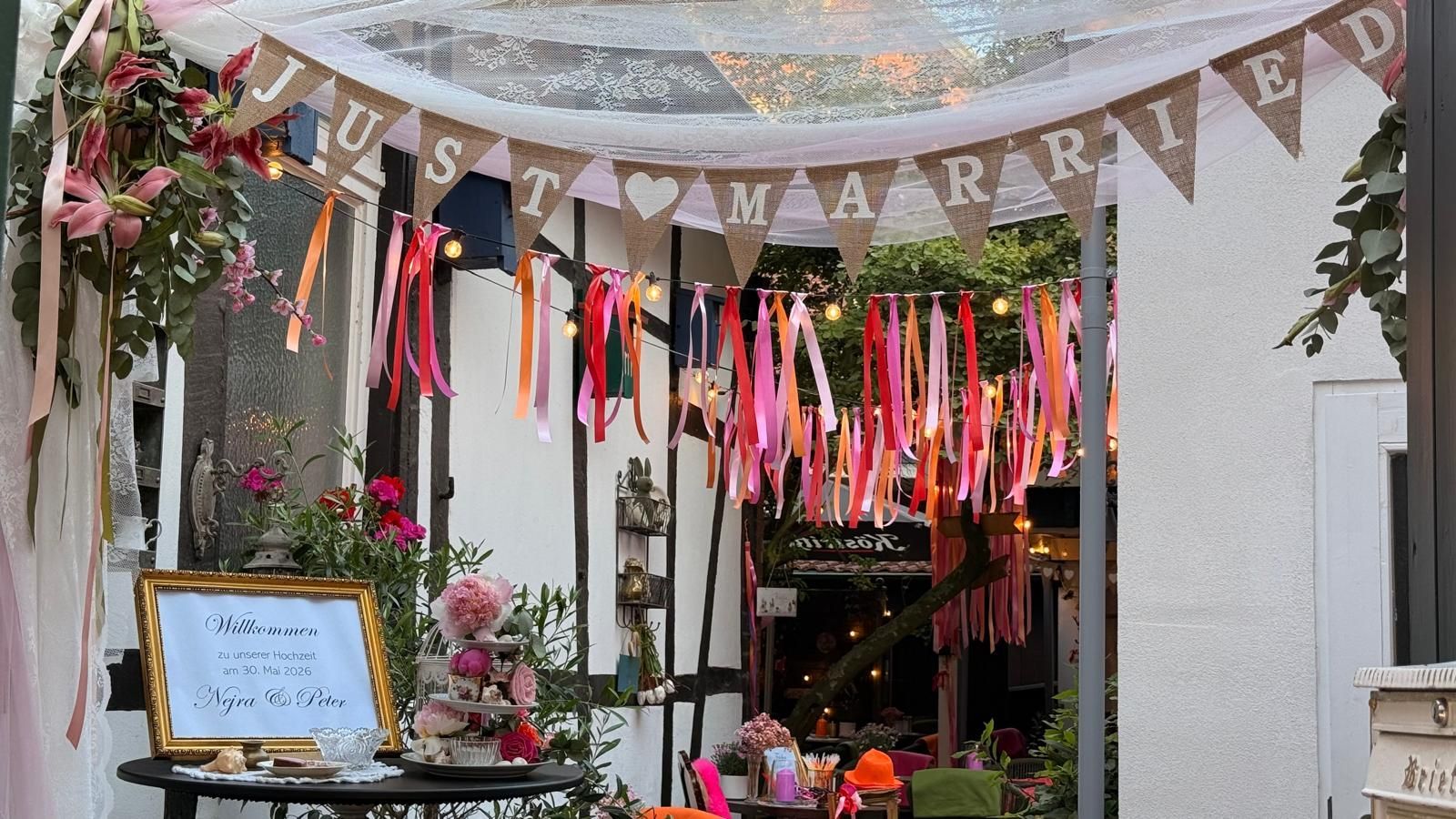 Der Ladeneingang wurde mit Wimpelketten, bunten Bändern, Blumen und einem Kreidetafelschild geschmückt.