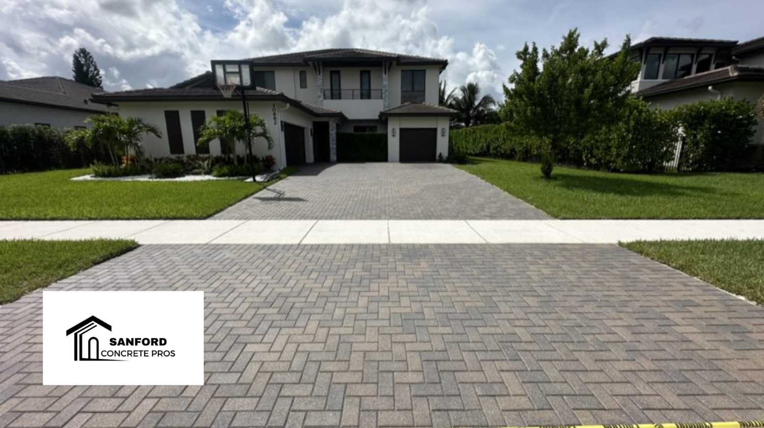 A brick driveway with a house in the background