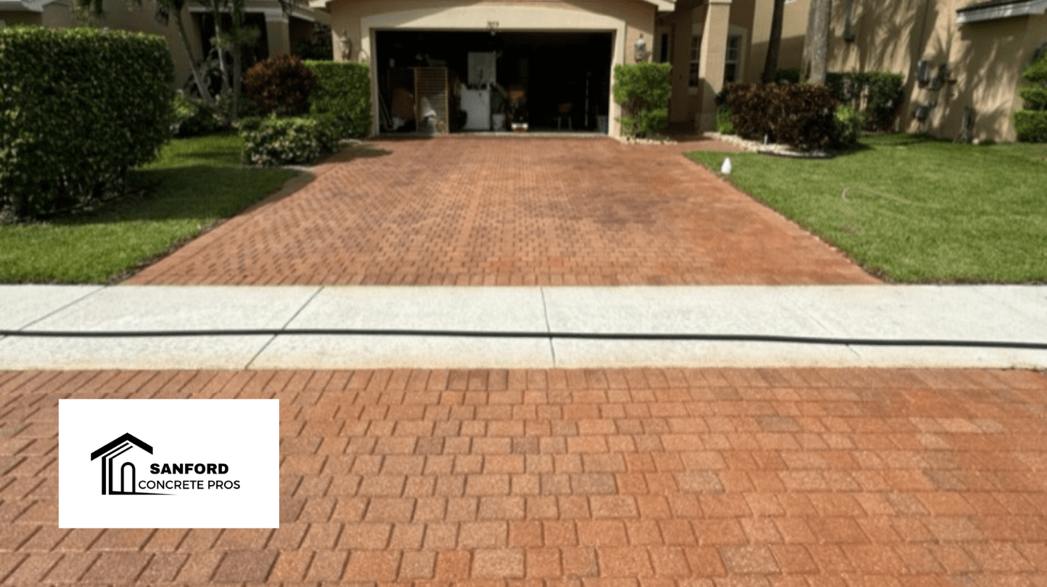 A brick driveway is leading to a house with a garage.