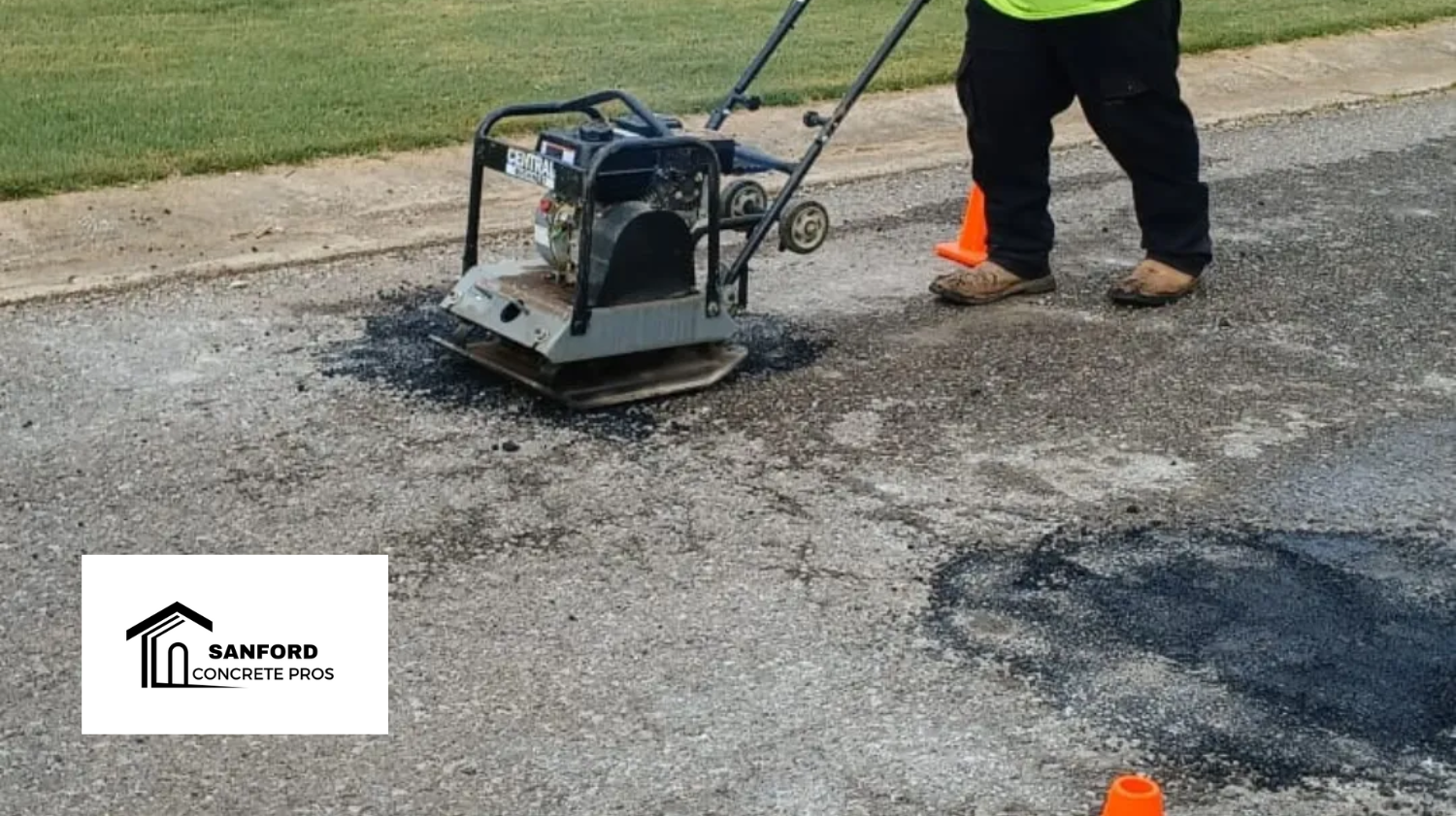 A man is using a machine to patch a hole in the road.