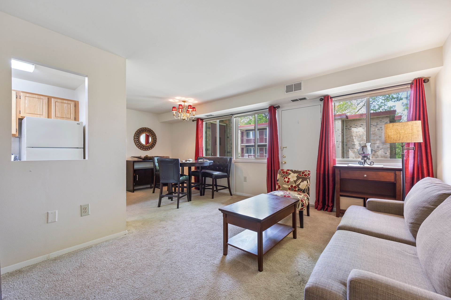 A living room with a couch , chair , coffee table and dining table.