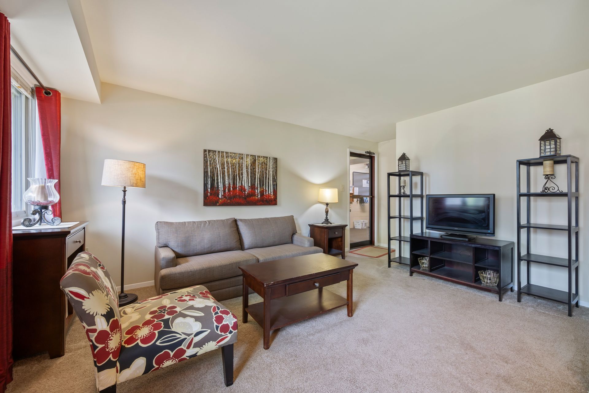 A living room with a couch , chair , coffee table and television.