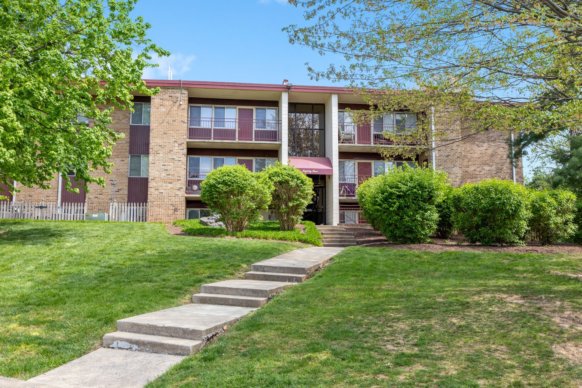 A large apartment building with a walkway leading to it.