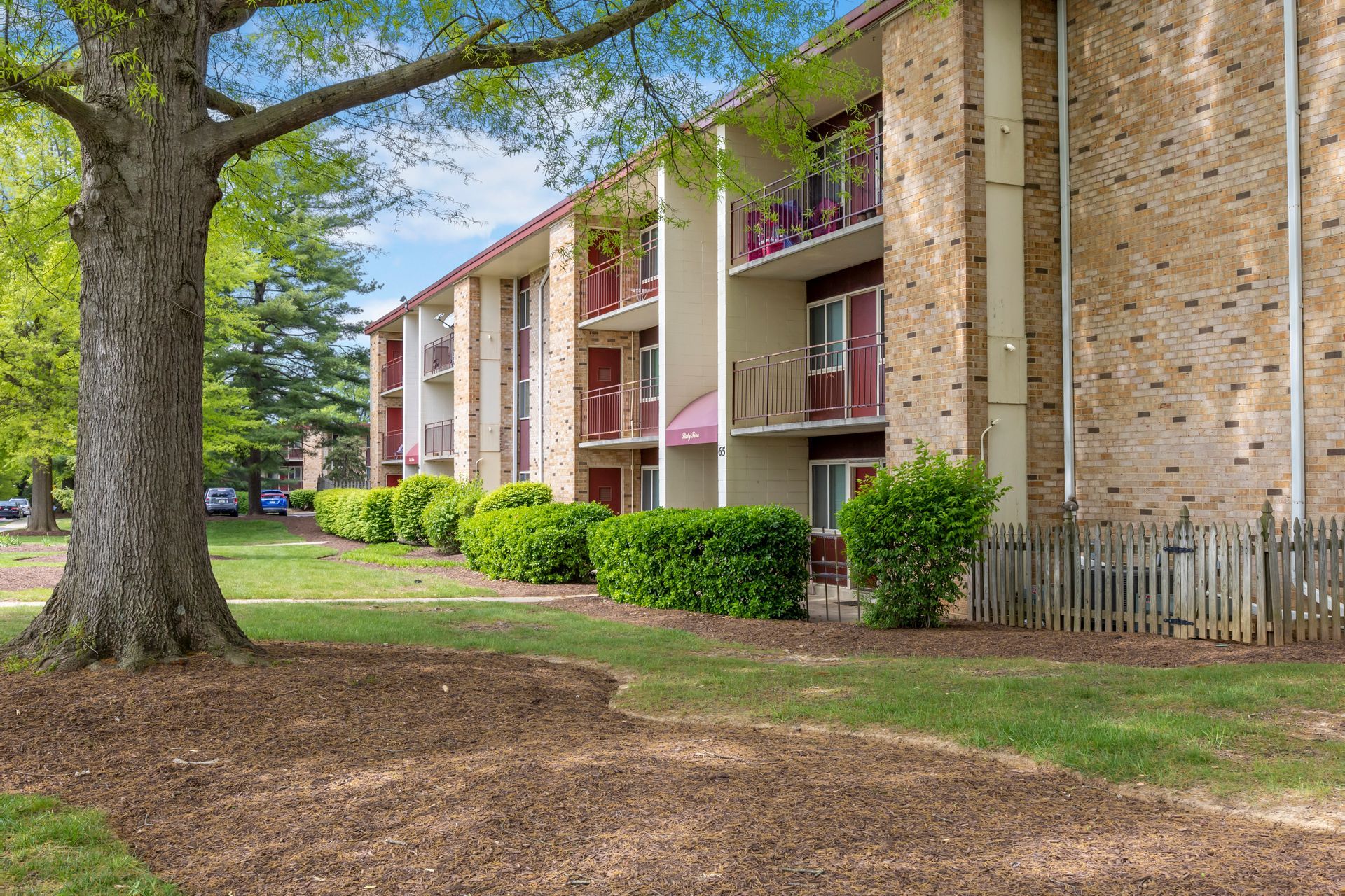 A large brick apartment building with a tree in front of it.