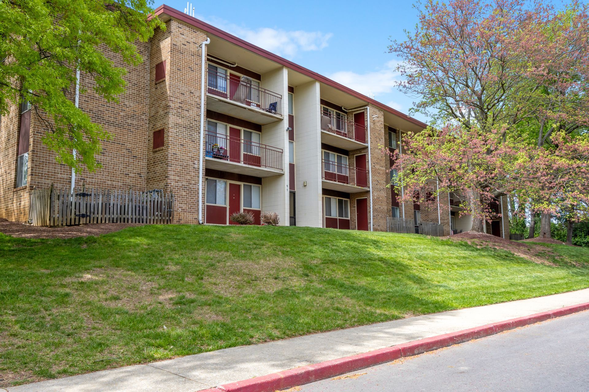 A large apartment building with a lush green lawn in front of it.