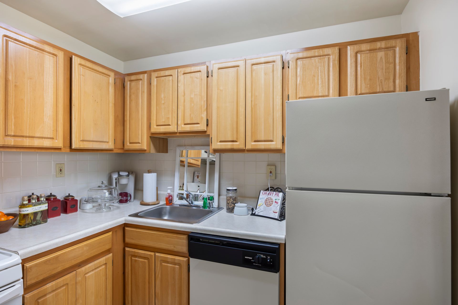 A kitchen with wooden cabinets and a white refrigerator.