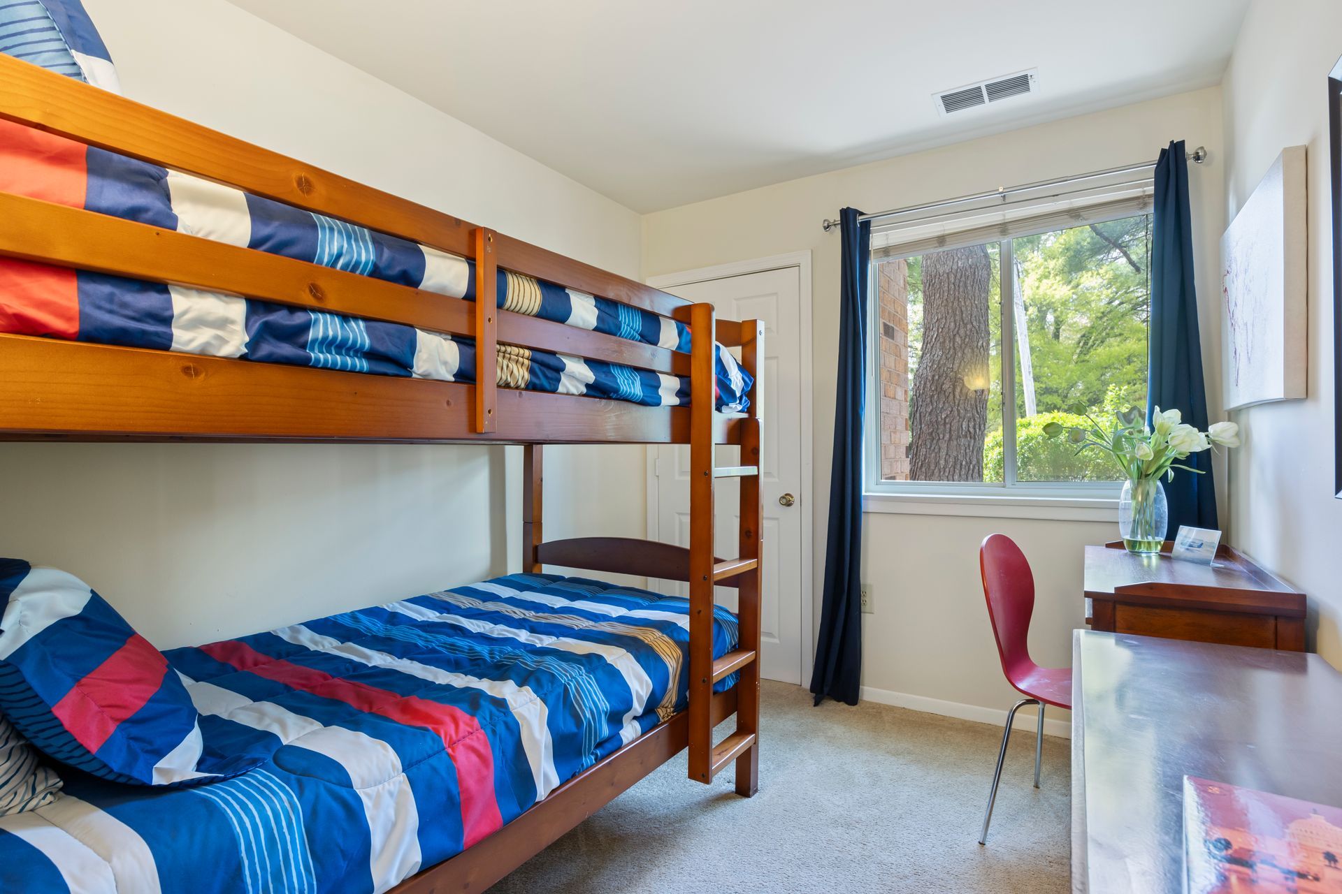 A bedroom with two bunk beds and a desk.