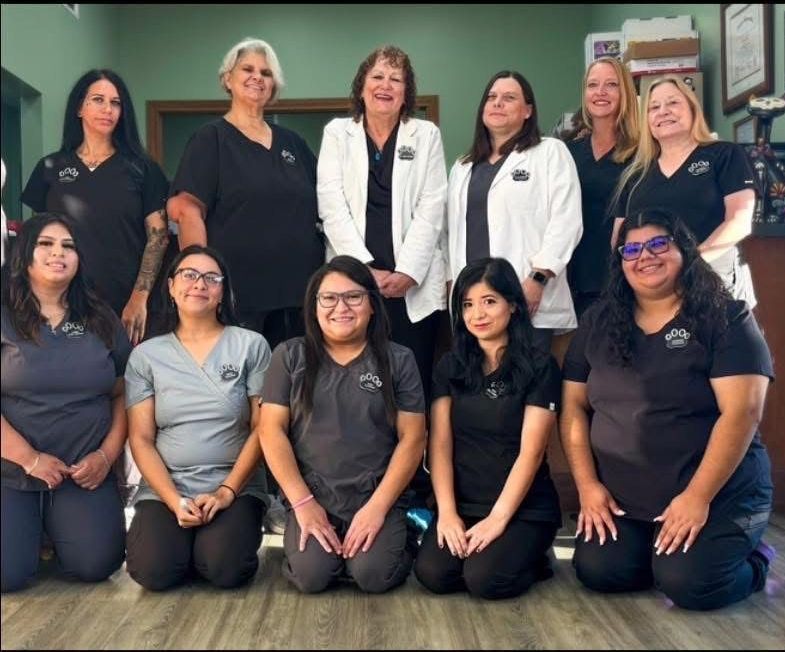 A group of women in blue scrubs are posing for a picture.
