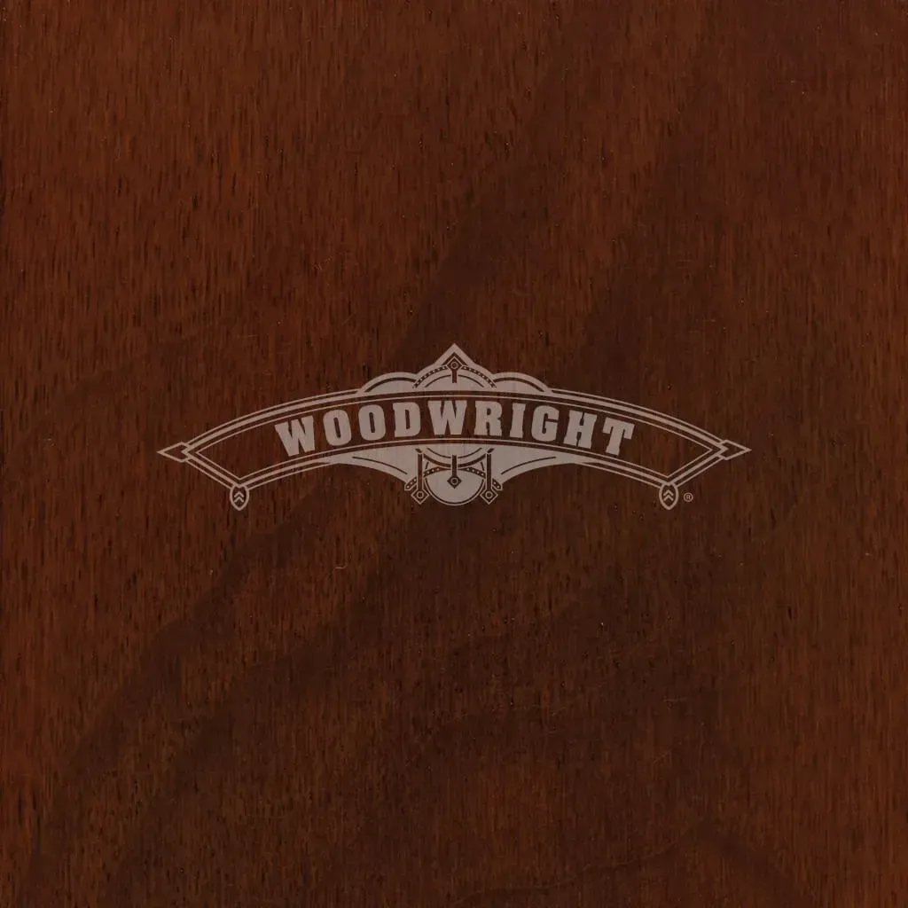 Woodwright logo in silver on a dark wood background.