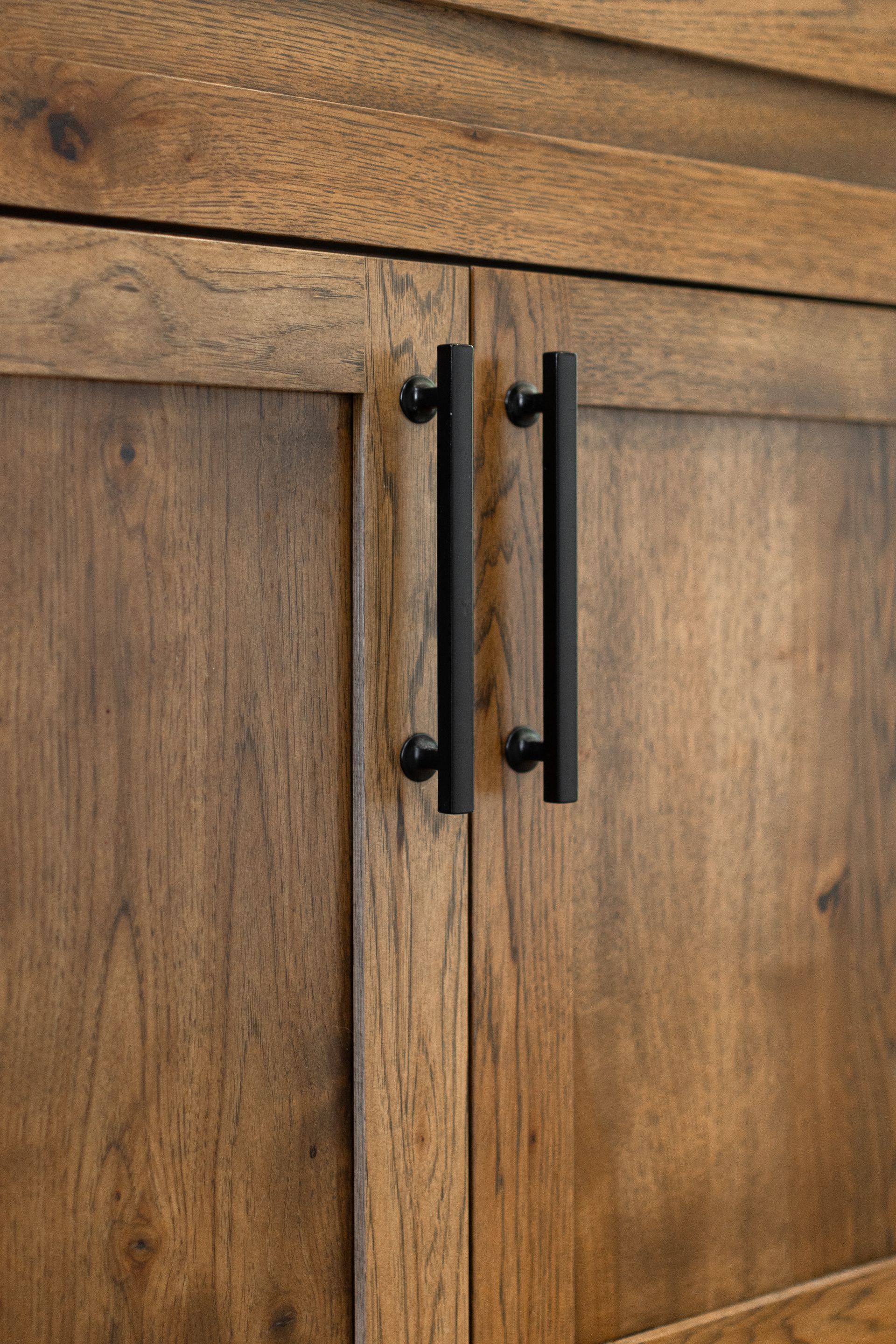Wooden cabinet doors with black bar handles.