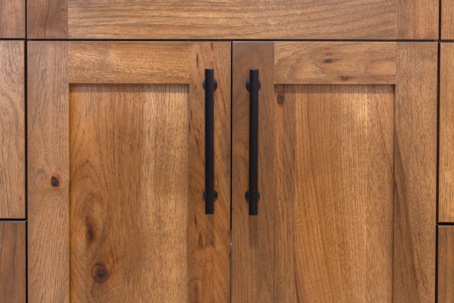 Wooden cabinet doors with black handles.