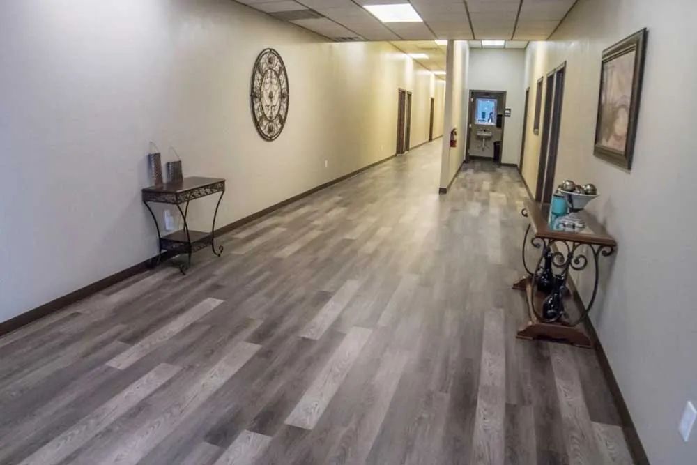 a long hallway with a table and a clock on the wall