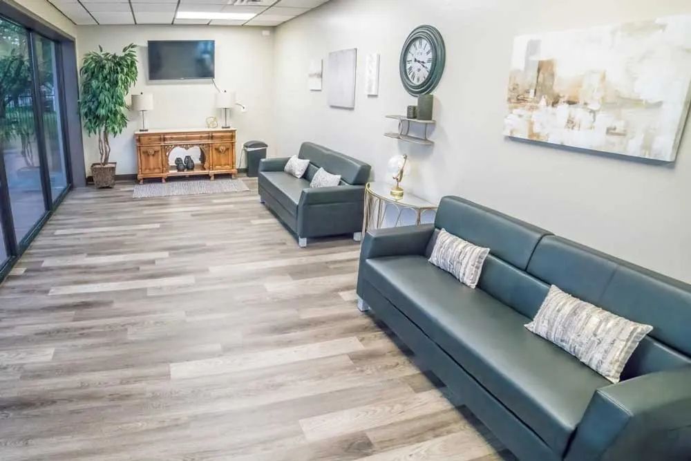 a waiting room with two couches and a clock on the wall