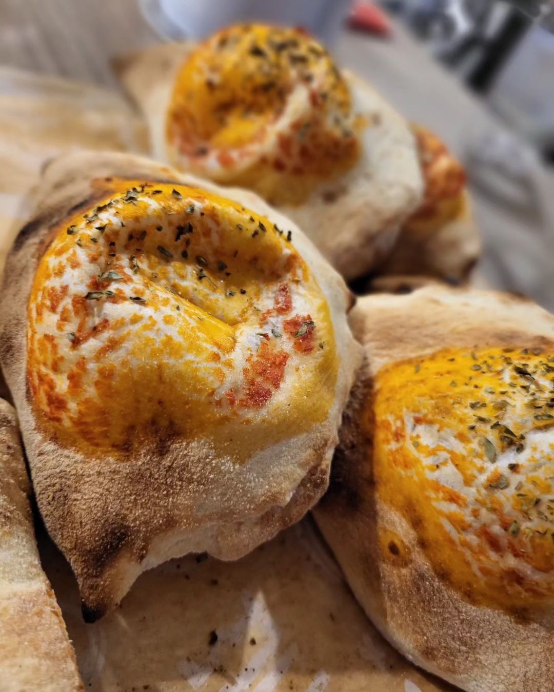 Panini appena sfornati con la superficie dorata e semi di sesamo su un vassoio