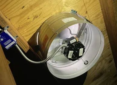 Open white ceiling light housing with exposed wiring and a black electrical component inside.