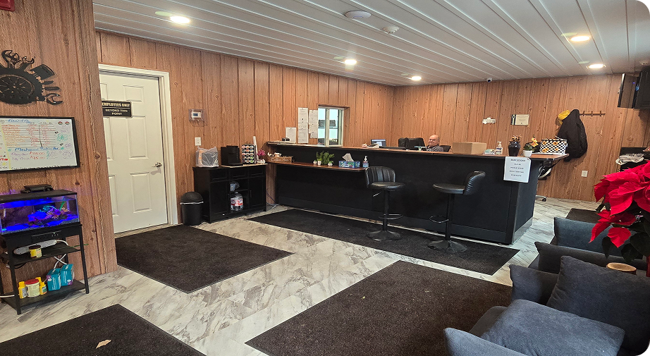 Wood-paneled office with a long black desk, dark rugs, and a chair in the foreground | Hauger's Automotive Services