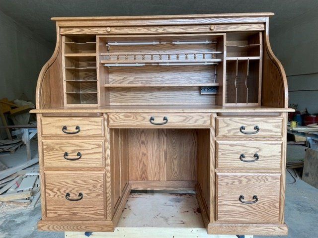 Wooden roll-top desk with multiple drawers, compartments, and a pull-down cover.