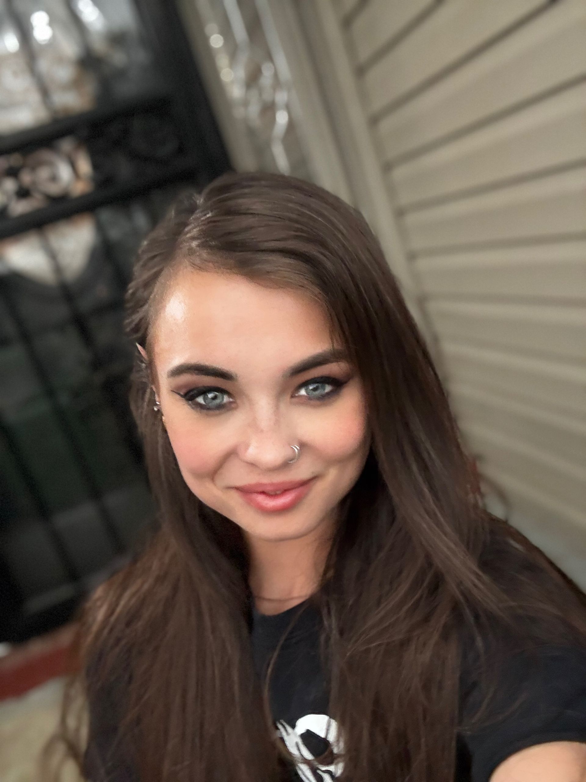 A woman with long brown hair is smiling for a picture.