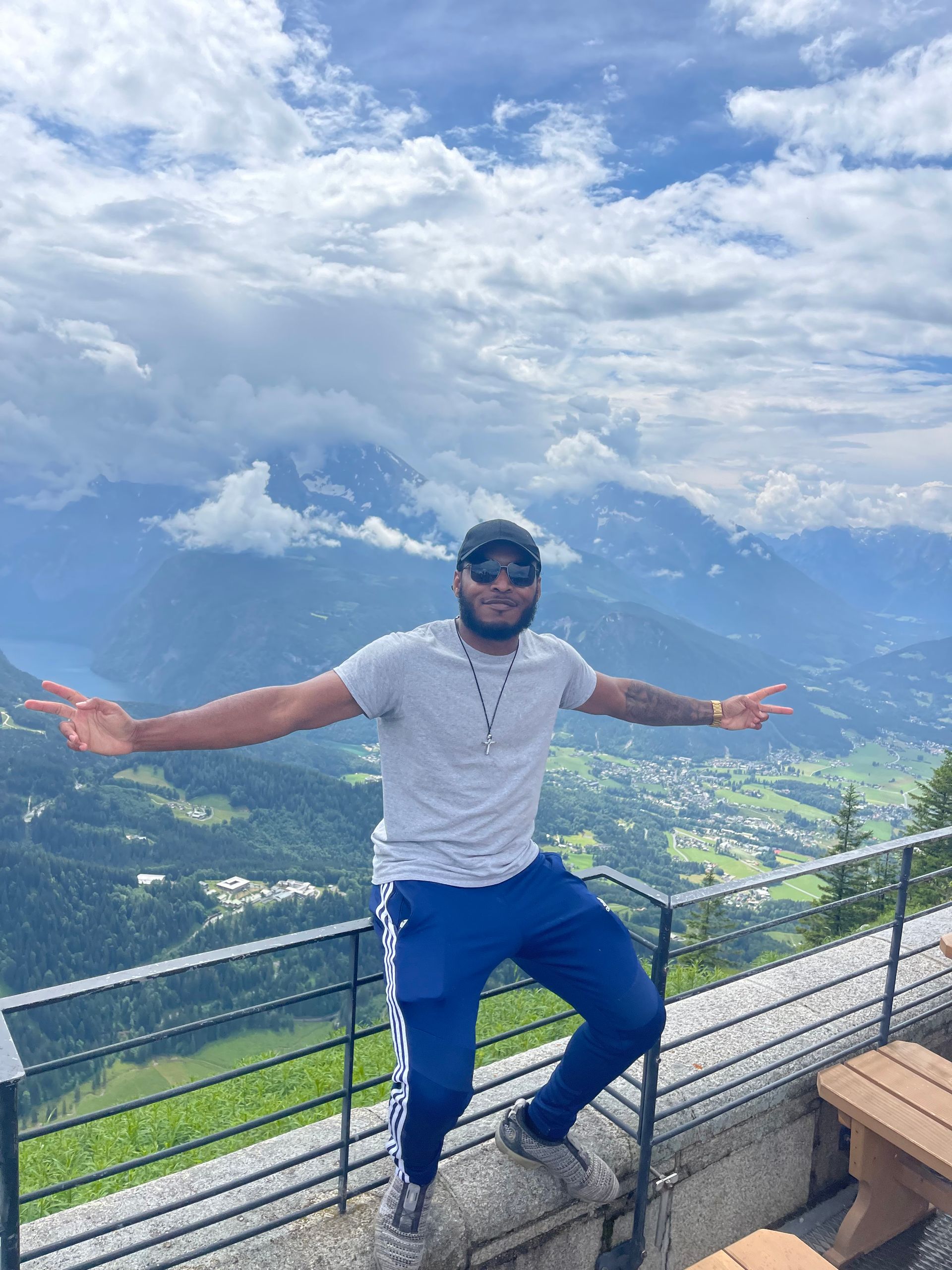 A man is standing on top of a mountain with his arms outstretched.