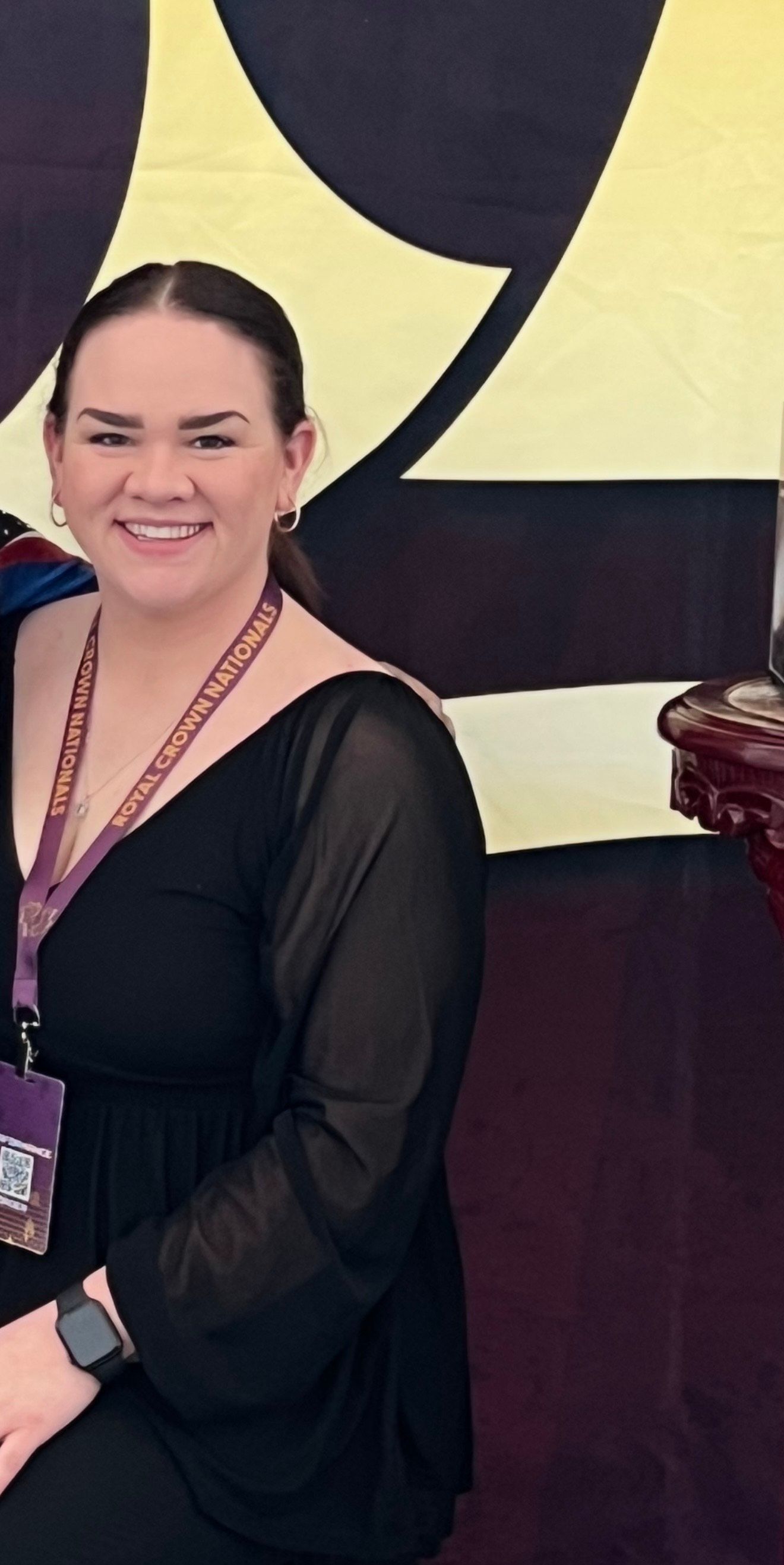 A woman in a black dress is smiling for the camera