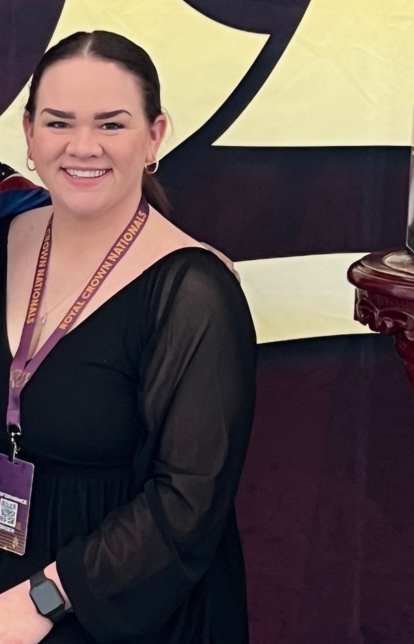 A woman in a black dress is smiling for the camera