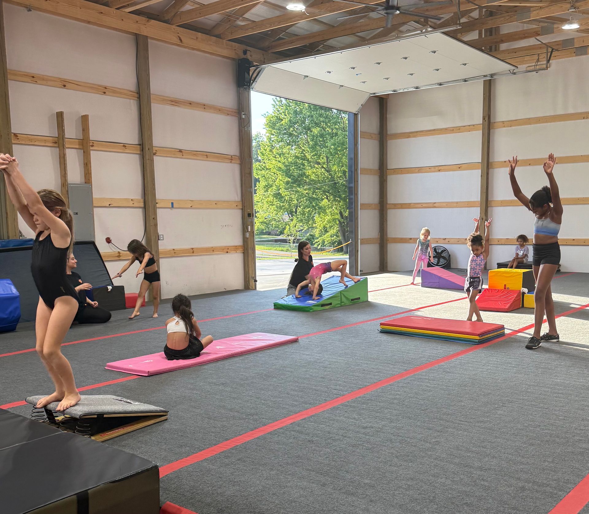 Gymnastics class in a large indoor space. Children practice poses and balance skills.