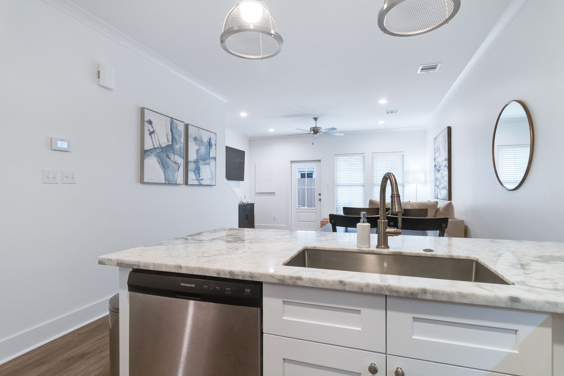 A kitchen with a sink , dishwasher , and mirror.
