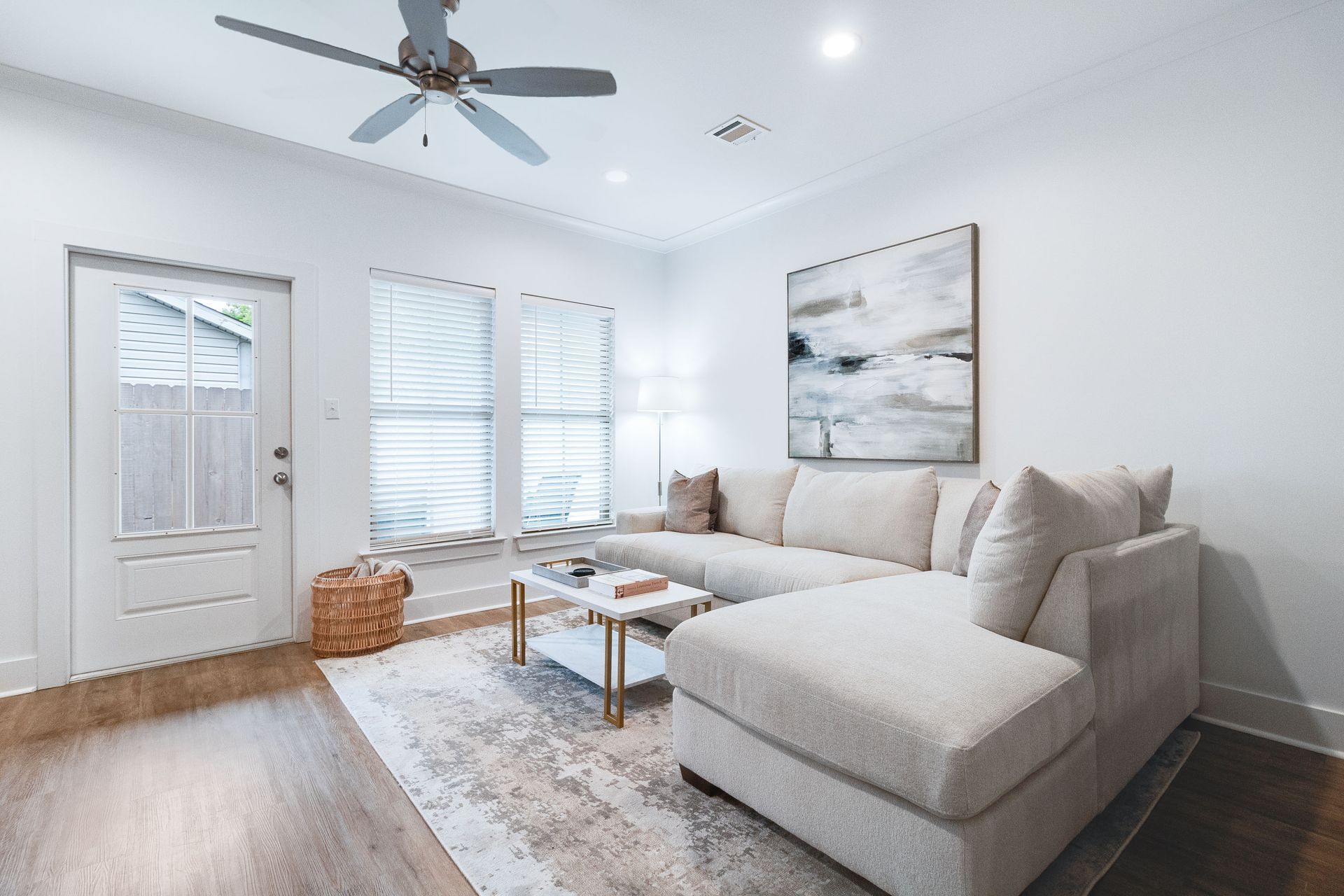 A living room with a couch , coffee table , and ceiling fan.