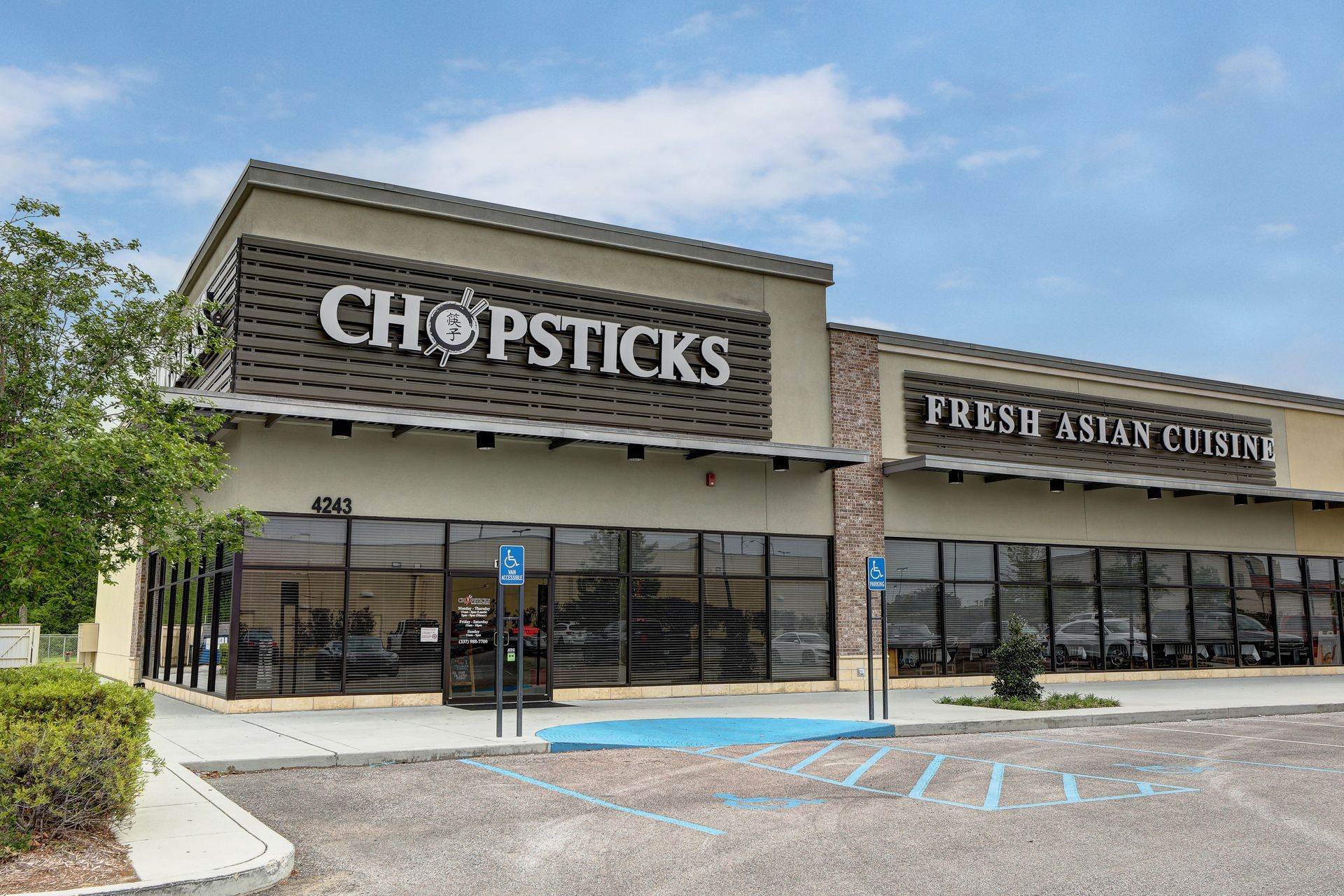 A chopsticks restaurant with a parking lot in front of it.