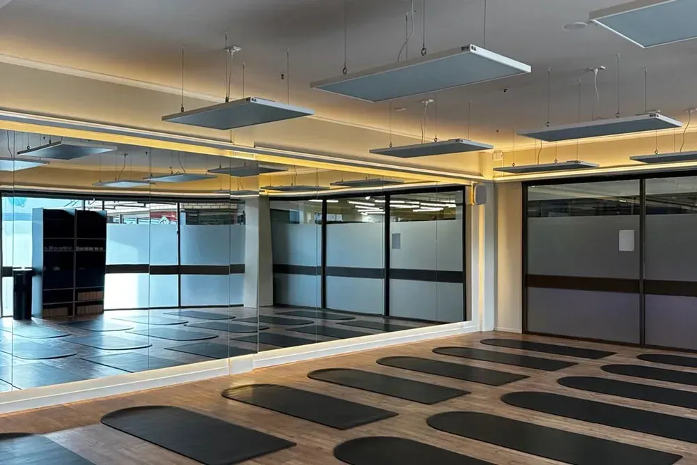 Empty office space with glass walls, ceiling lights, and patterned carpet tiles— Confac Energy Services in Moonah, TAS
