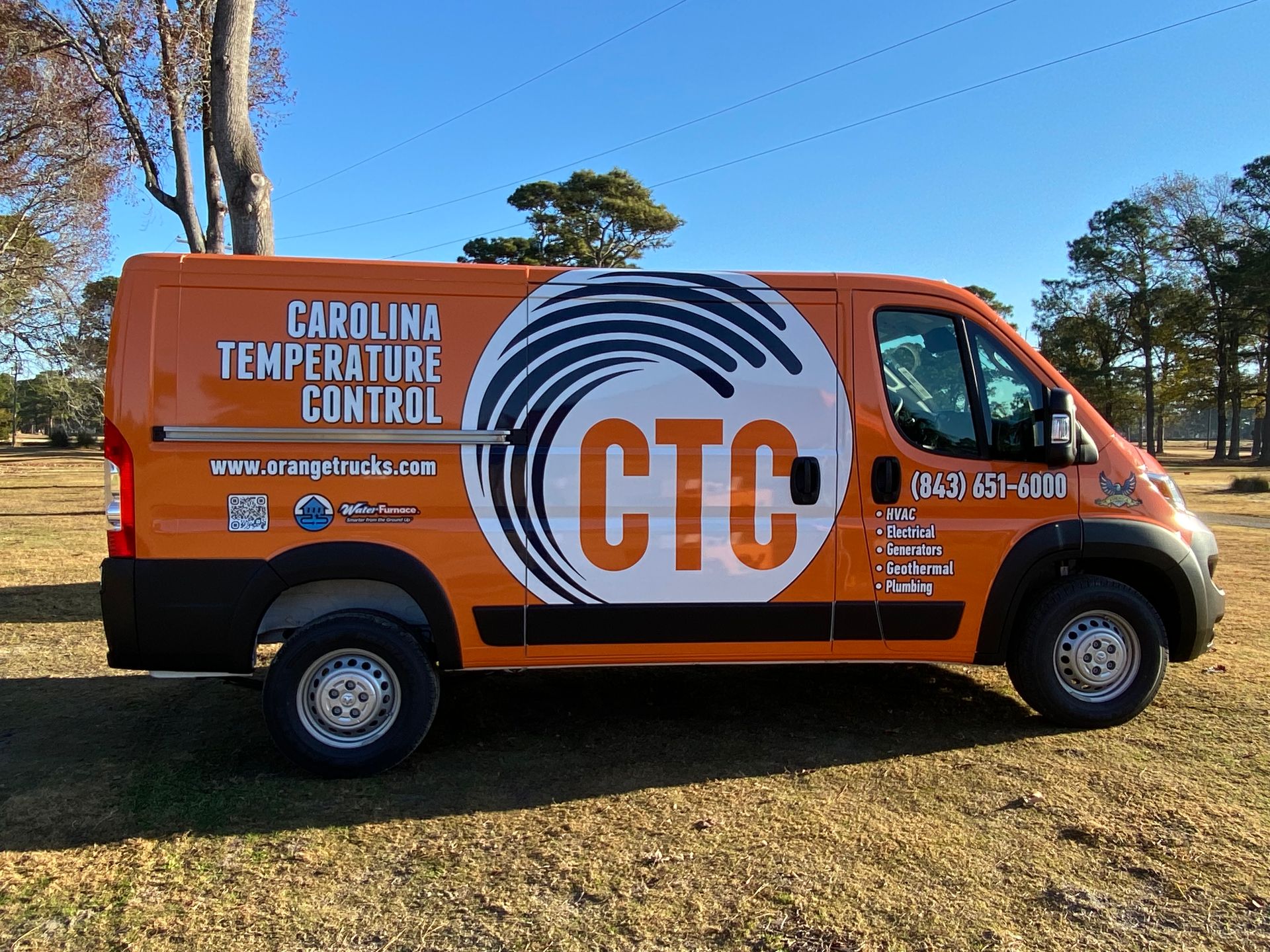 Orange Carolina Temperature Control van parked on grass. Has company logo: CTC inside a blue and white swirl.