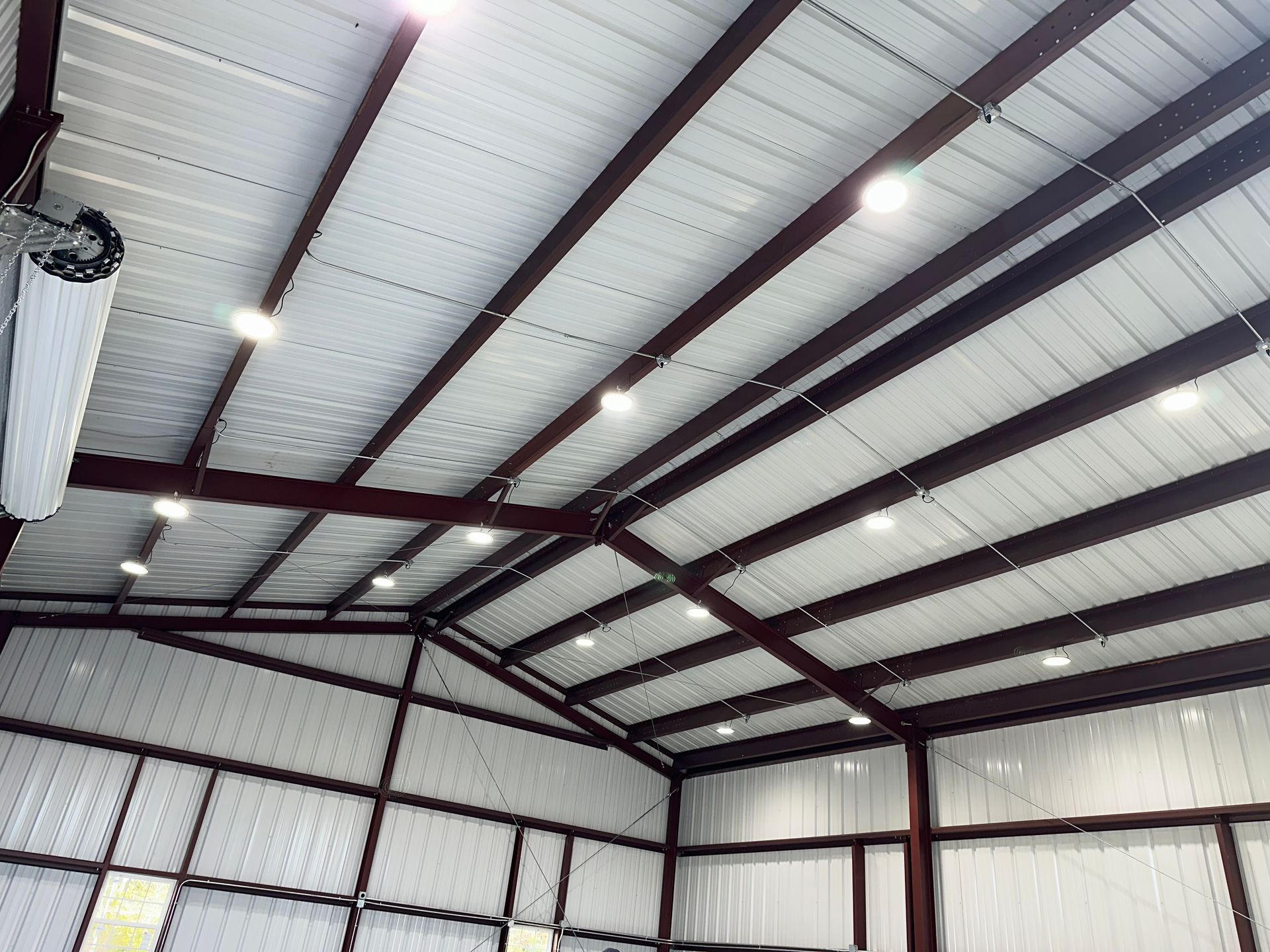 Interior of a metal warehouse with exposed beams and bright overhead lights