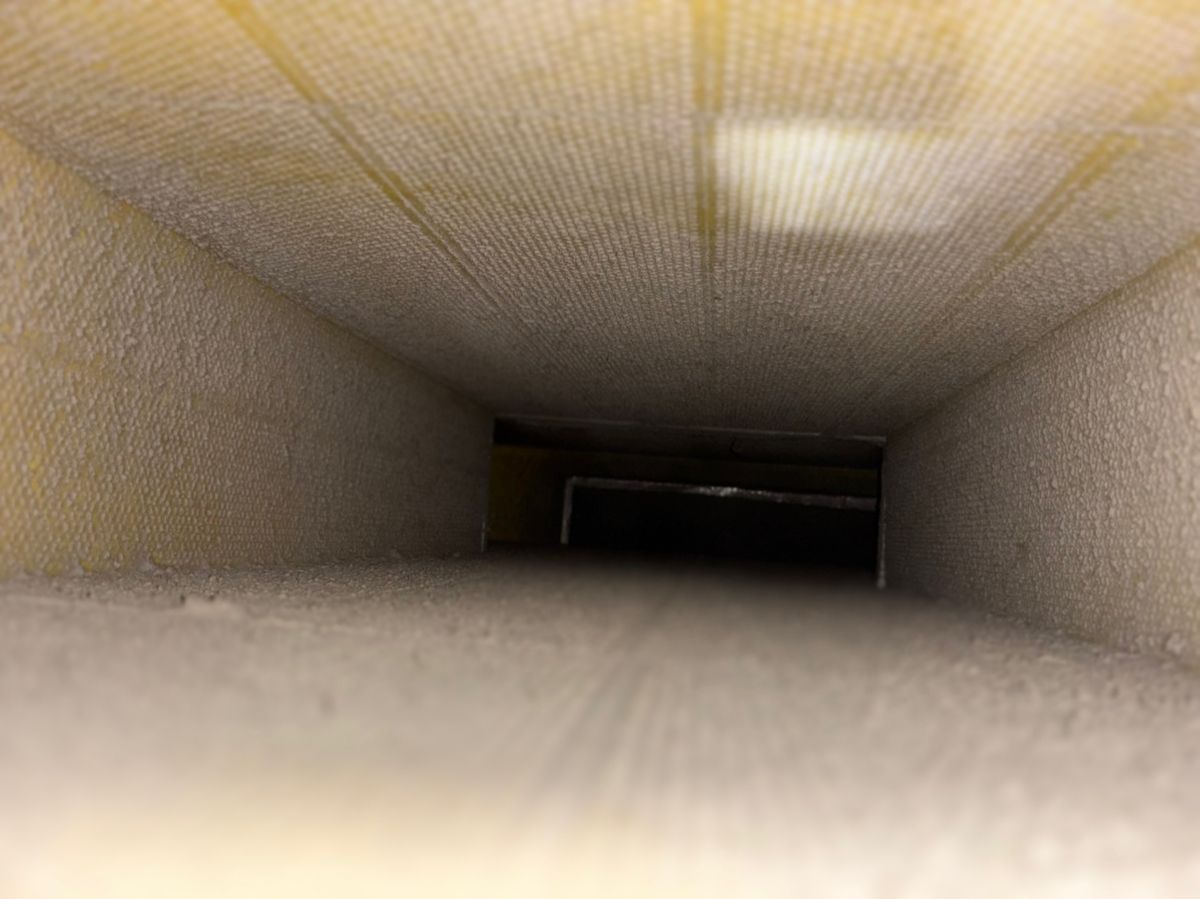 Technician using a brush to clean air ducts
