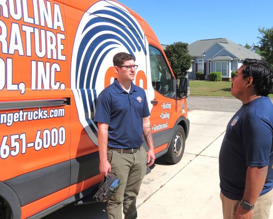 Two CTC technicians standing in front of a CTC orange truck 